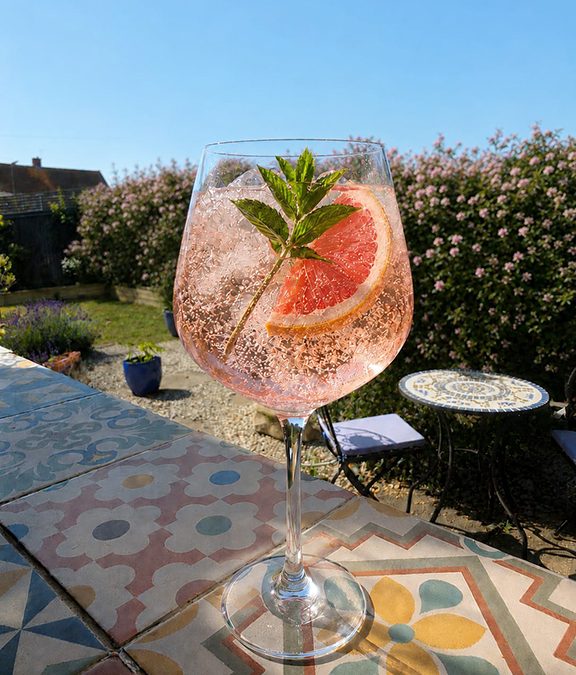 Pink Hue Go Spritz made with Pink Elderflower Liqueur, rosé prosecco, soda, grapefruit and mint.